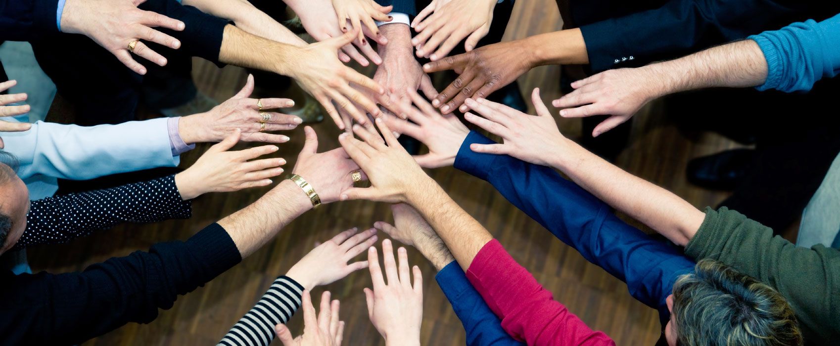 A group of hands coming together in the centre