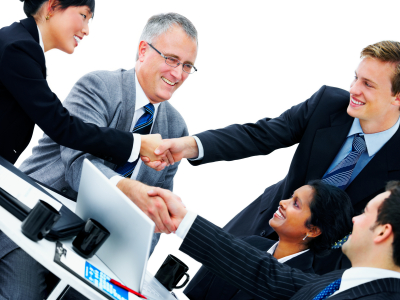 A group of business persons shaking hands and smiling.