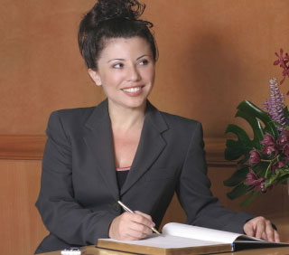 A woman looking at a client at hotel front desk