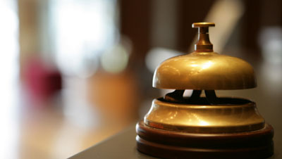 A photo of a call bell on a wooden desk.